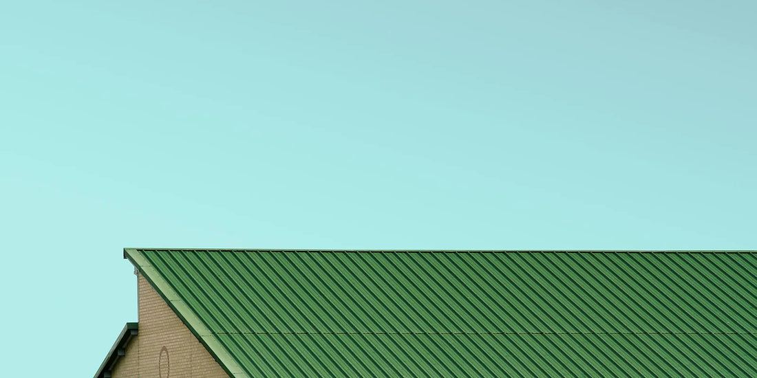 Ribbed green steel roof sheeting against a pale sky