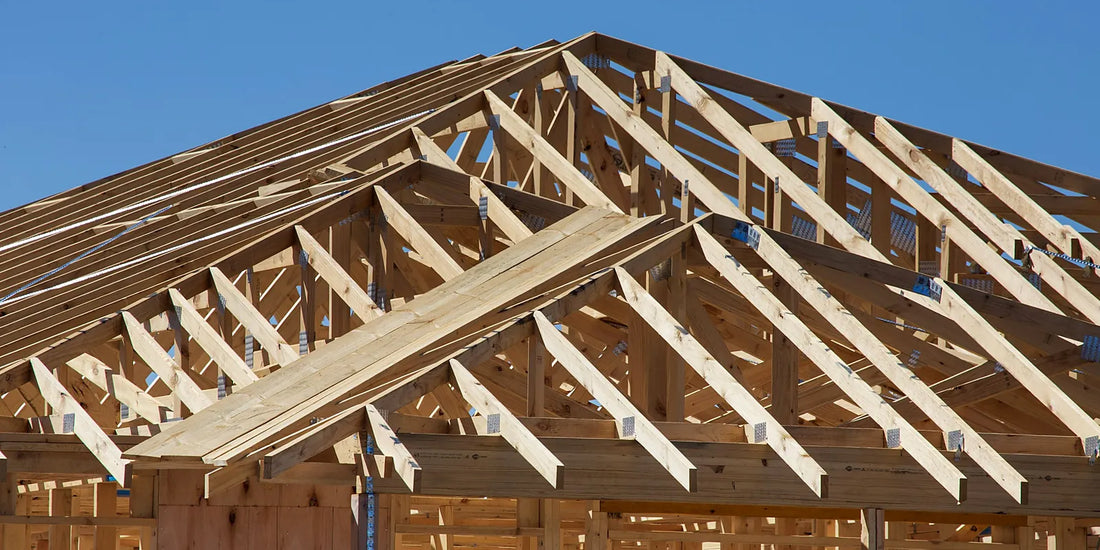 Timber roof trusses on an Australian house frame against a clear blue sky