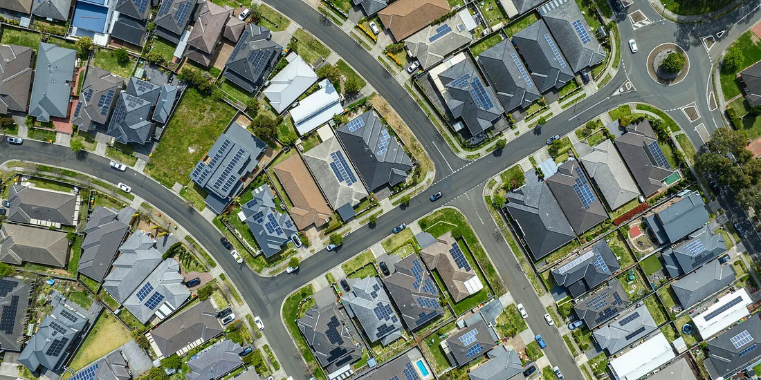 Aerial view of an established Australian suburb with tiled roofs and rooftop solar panels