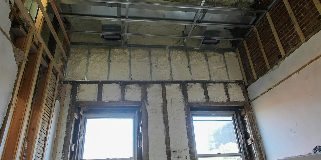 Room under construction showing insulation in the ceiling and walls before plasterboard