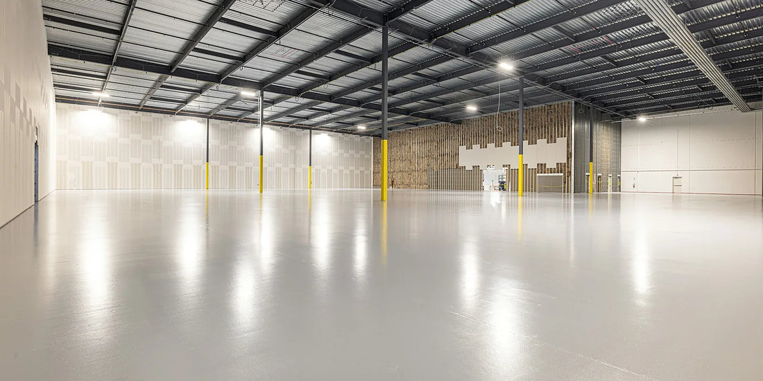 Empty warehouse interior with an exposed steel roof structure and no ceiling lining