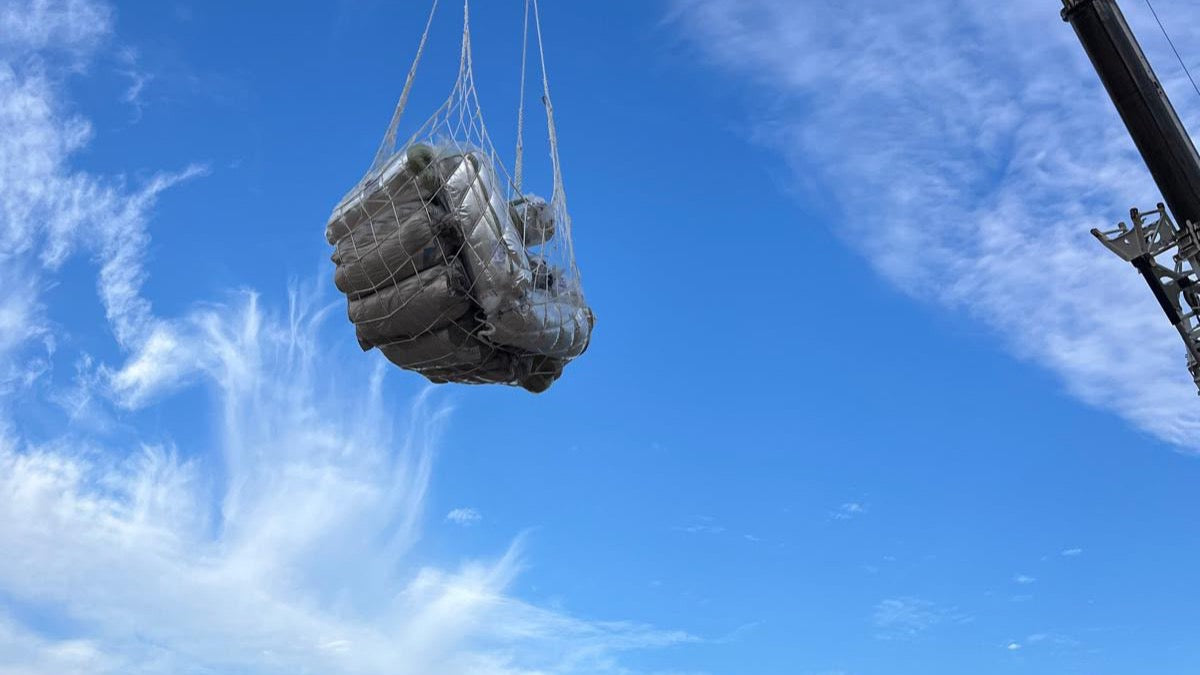 Crane delivering insulation to a commercial building site