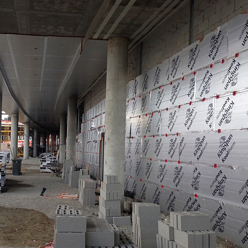 Kooltherm cavity boards fixed to a concrete block wall on a commercial site