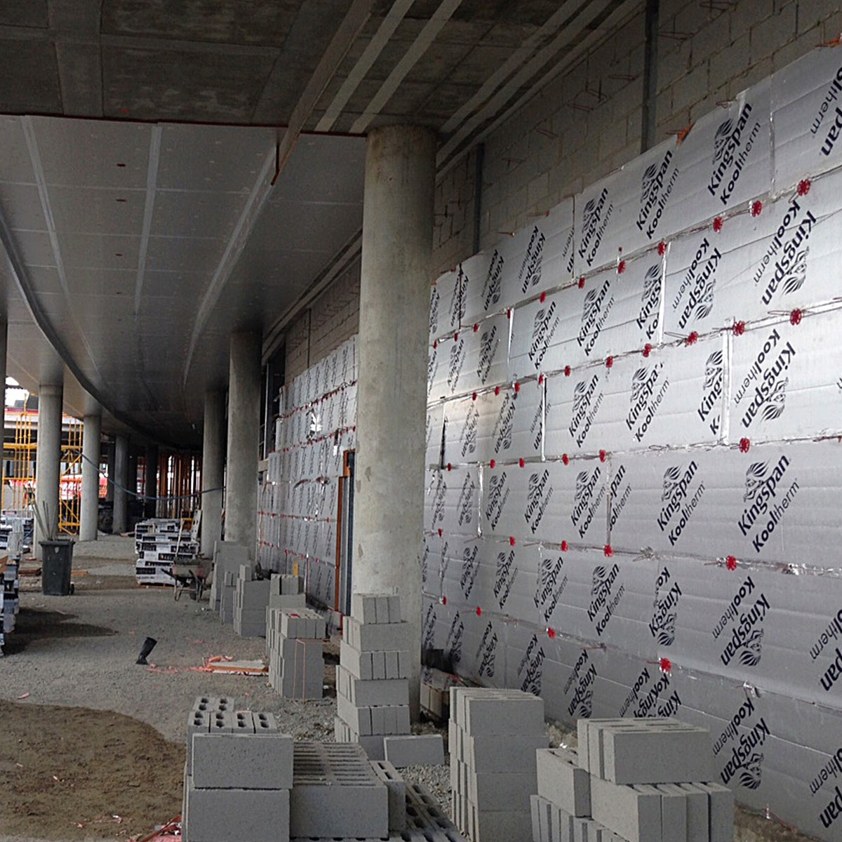 Kooltherm cavity boards fixed to a concrete block wall on a commercial site